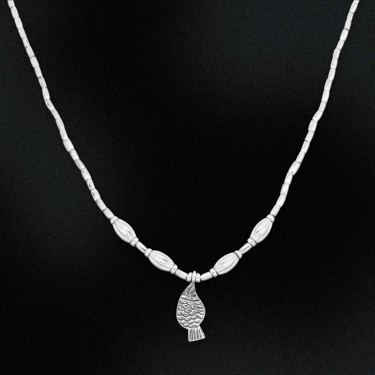Silver necklace with a pendant on a black background