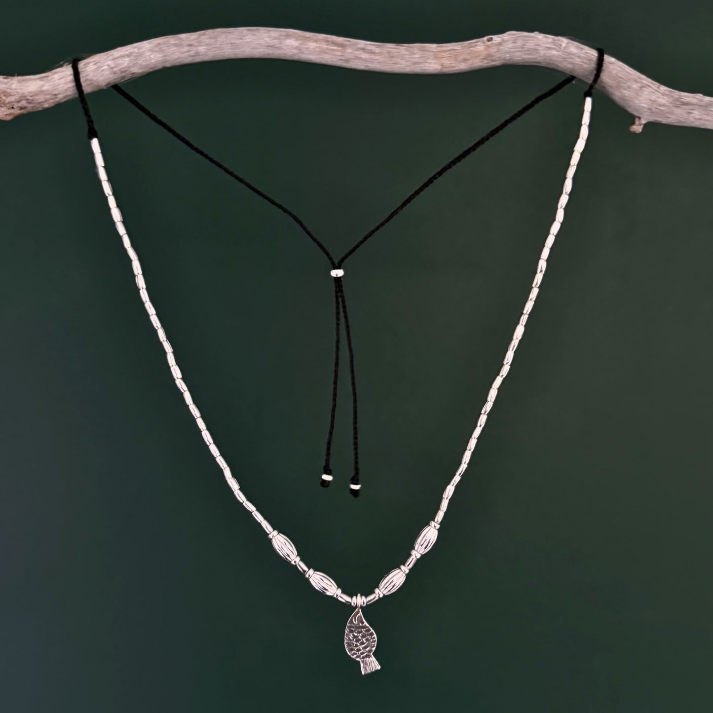 Necklace with a pendant on a branch against a dark background