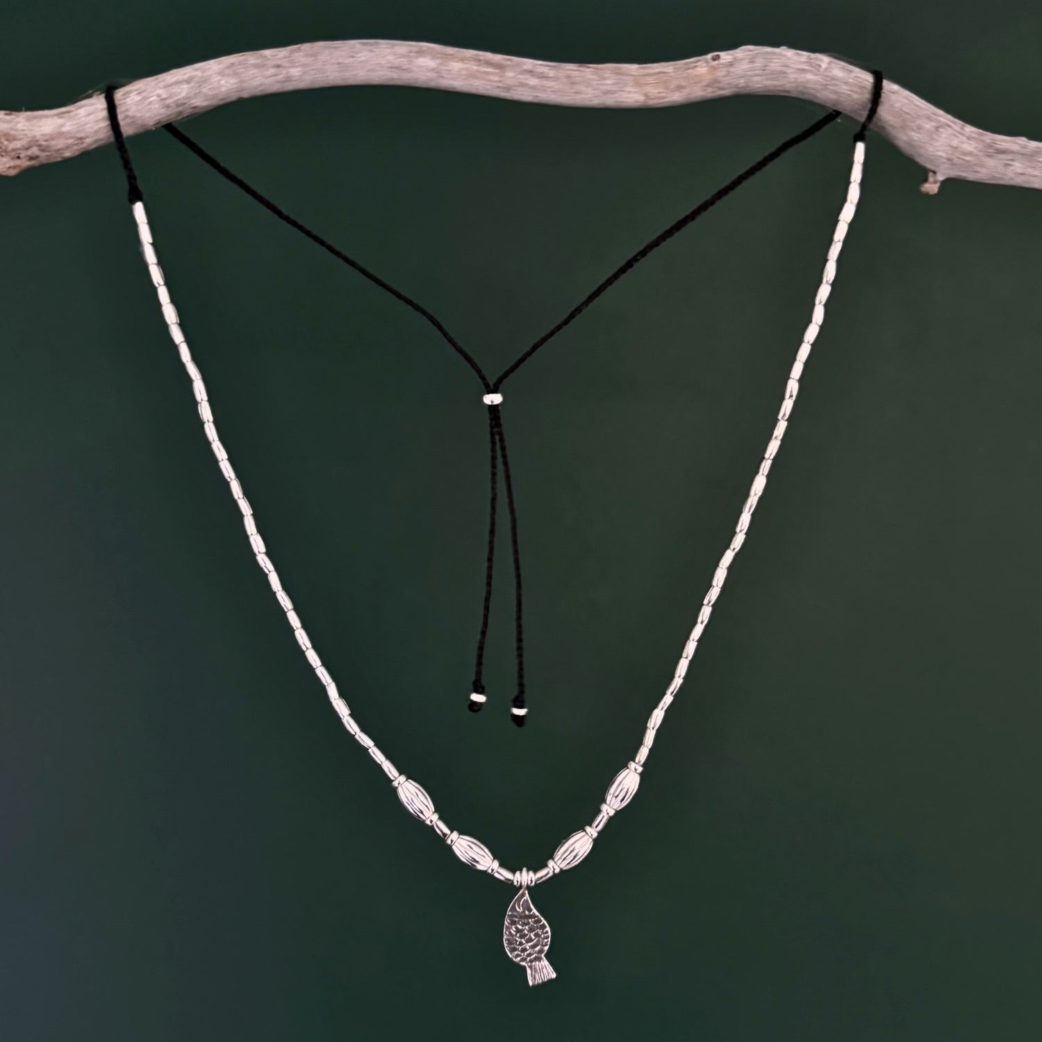 Necklace with a pendant on a branch against a dark background