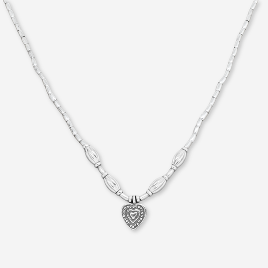Silver necklace with a heart-shaped pendant on a white background