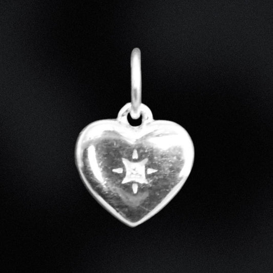 Silver heart-shaped pendant with star design on a black background