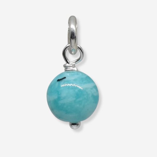 Turquoise bead pendant with silver bail on a white background