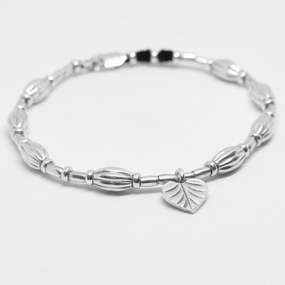 A true work of art. Handcrafted with intricate detail, this bracelet features a heart leaf charm at its centrepiece that is sure to capture your heart. The charm is complemented by corrugated beads that add a textural element to the bracelet. ﻿ Crafted from high-quality Hill Tribe Silver, the delicate balance of the charm and the beads brings together a perfect harmony of nature and artistry that is sure to make you stand out from the crowd.