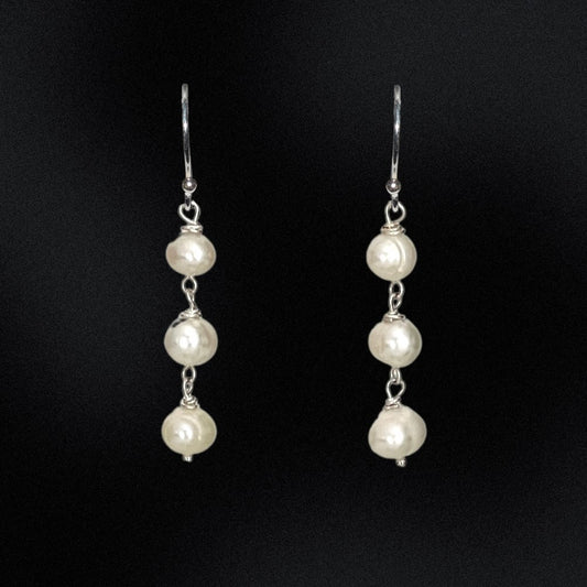 This exquisite Triple Freshwater Pearl Stack Earrings features three freshwater pearls delicately stacked and set in sterling silver. Perfect for adding a touch of elegance to any outfit. These earrings are too good to pass up!