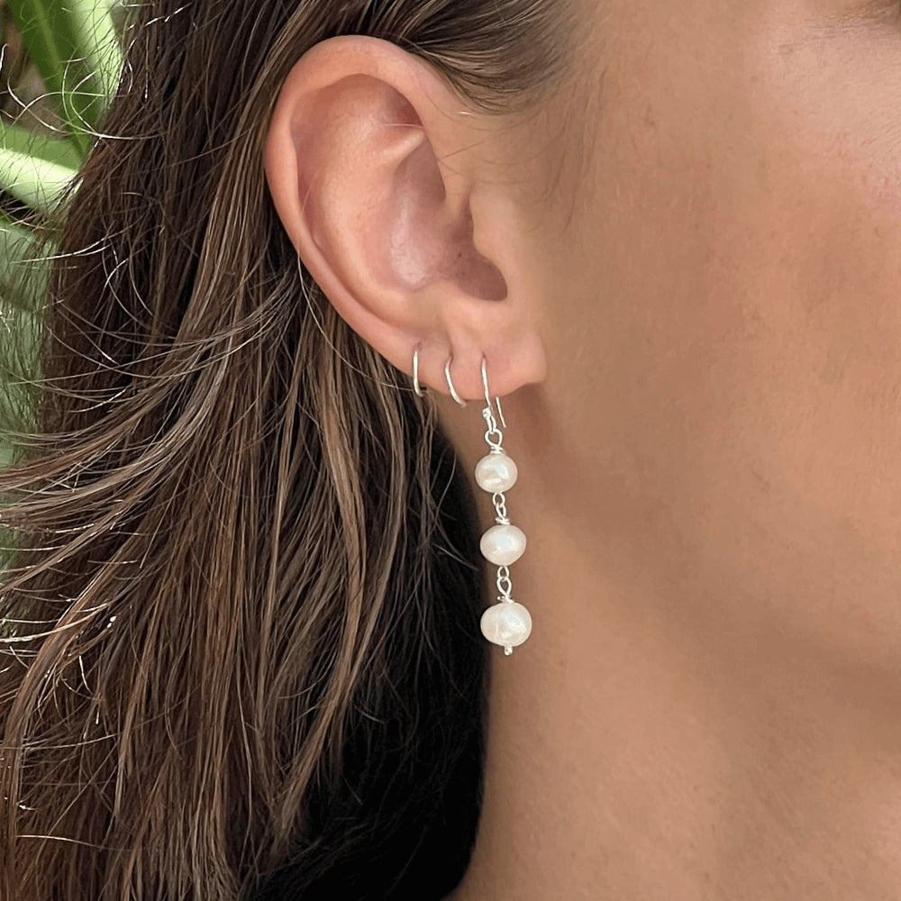 This exquisite Triple Freshwater Pearl Stack Earrings features three freshwater pearls delicately stacked and set in sterling silver. Perfect for adding a touch of elegance to any outfit. These earrings are too good to pass up!