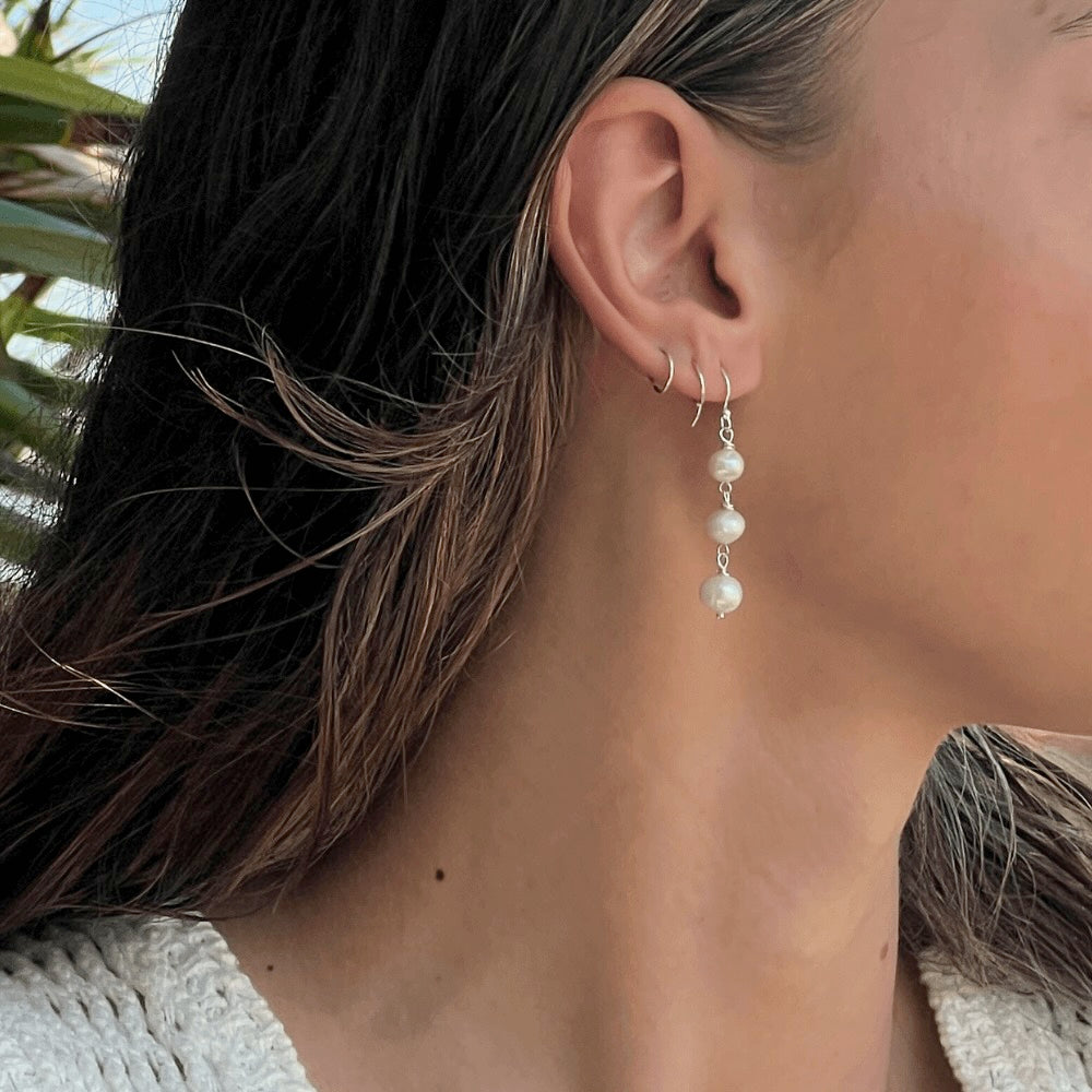 This exquisite Triple Freshwater Pearl Stack Earrings features three freshwater pearls delicately stacked and set in sterling silver. Perfect for adding a touch of elegance to any outfit. These earrings are too good to pass up!