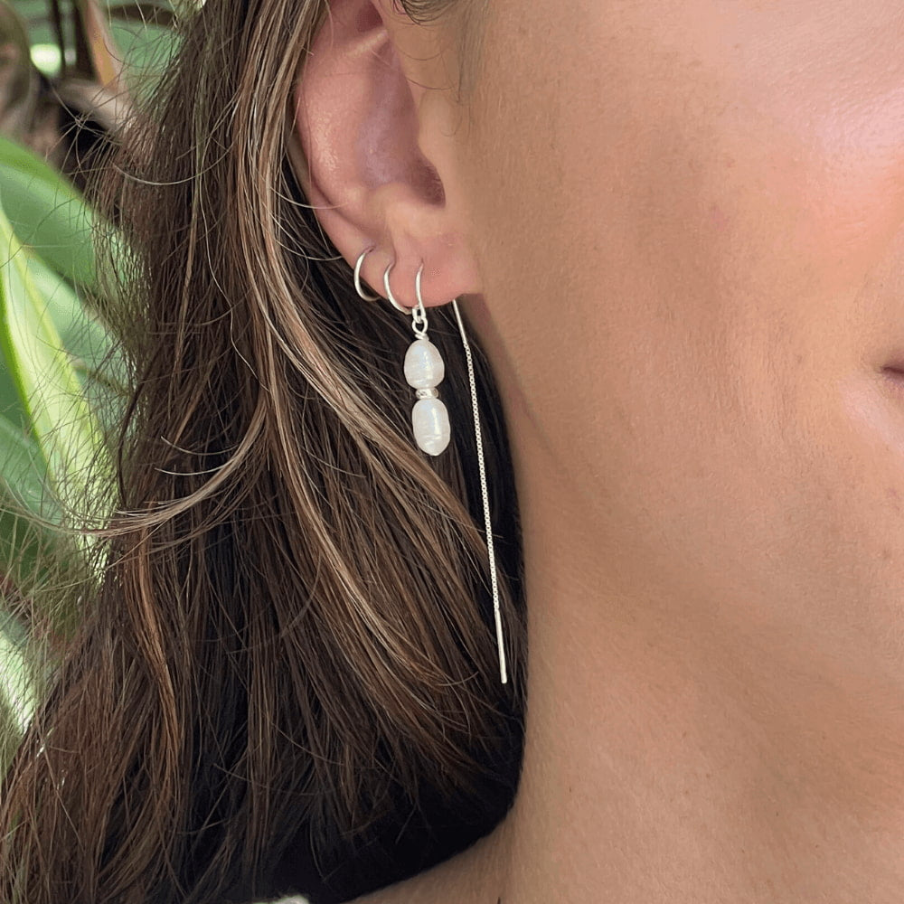 Add some drama and edge to your everyday look with these freshwater double pearl threader earrings! Handcrafted with two freshwater pearls and sterling silver, these earrings will make any outfit double-take fabulous. Perfect for any occasion, add a little pearl-fection to your wardrobe!