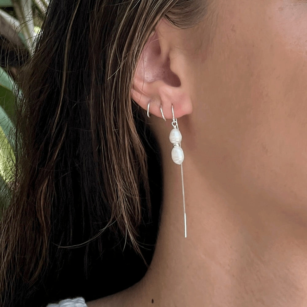Add some drama and edge to your everyday look with these freshwater double pearl threader earrings! Handcrafted with two freshwater pearls and sterling silver, these earrings will make any outfit double-take fabulous. Perfect for any occasion, add a little pearl-fection to your wardrobe!