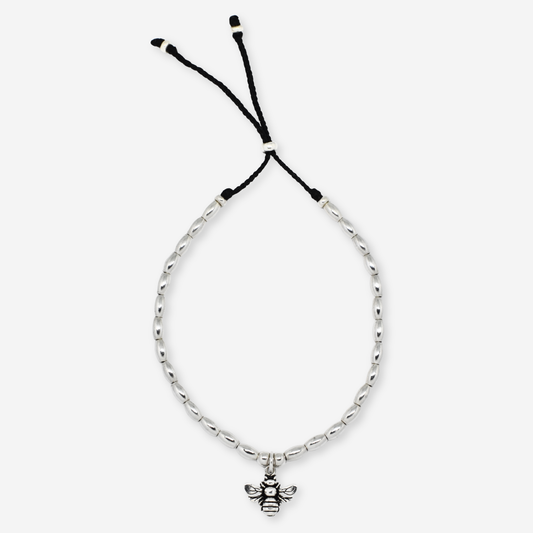 Silver bracelet with a bee charm on a white background