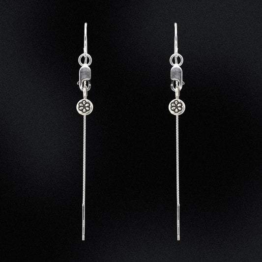 Pair of silver threader earrings on a black background