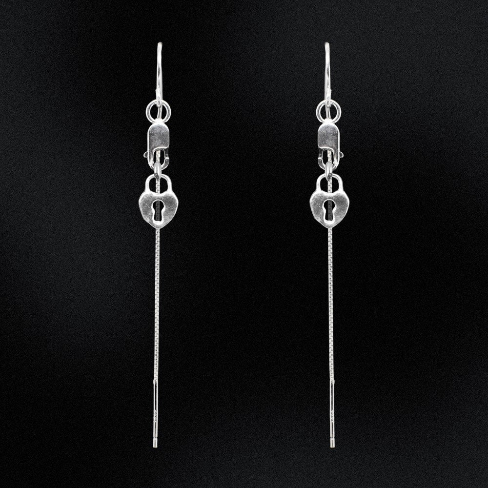 Pair of silver lock-shaped earrings on a black background
