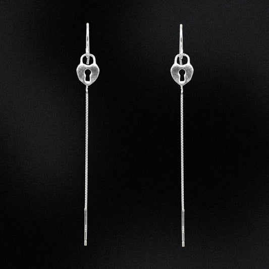 Pair of silver earrings with keyhole design on a black background